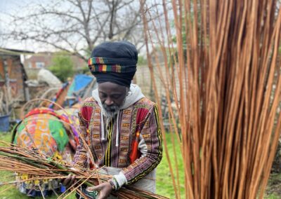 Kwame from African Activities works with willow in and of the New Forest with the Nightjar sculpture taking shape in the background.